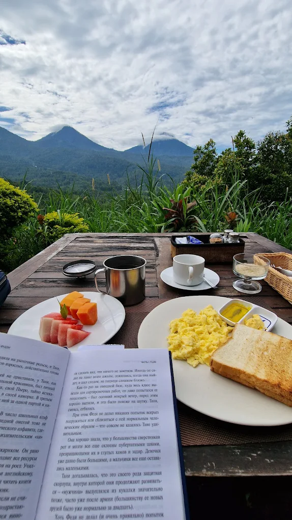 Morning coffee and a book with twin volcanoes behind