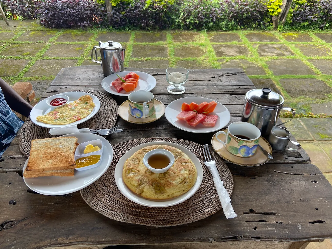 Breakfast spread on a rustic wooden table in the garden