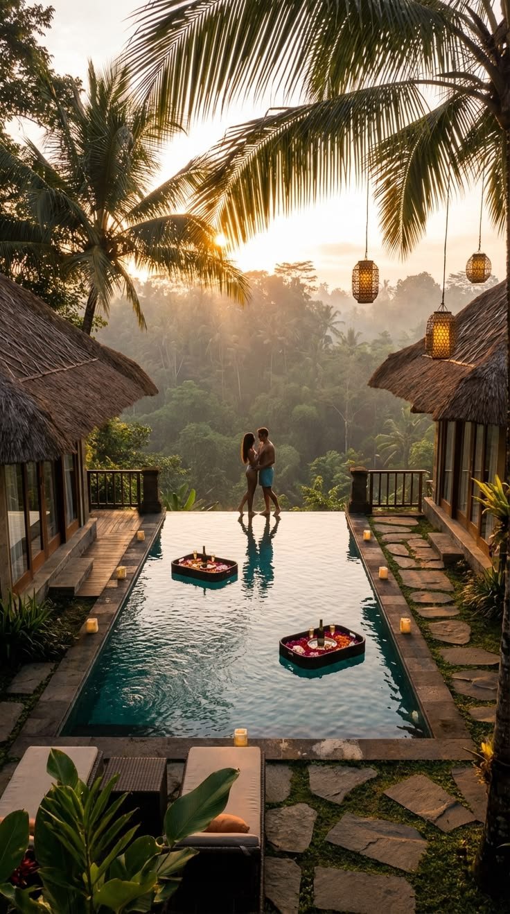 Couple in an infinity pool at golden sunset framed by palms and lanterns