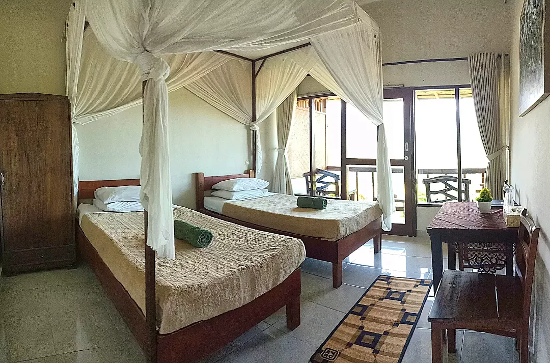 Twin bedroom with canopy nets opening onto a balcony